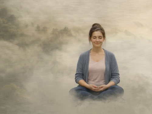 Jeune femme assise dans la brume en position de méditation